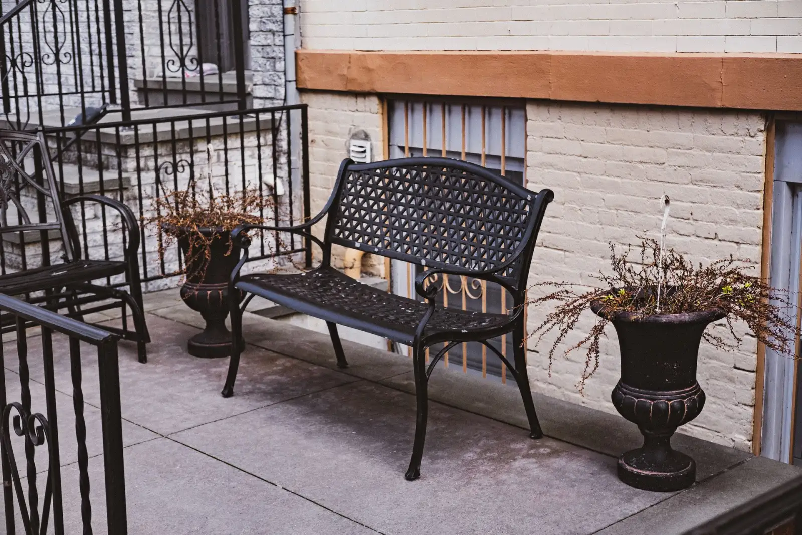 Concrete entry landing outside a commercial building with a bench and planters alongside