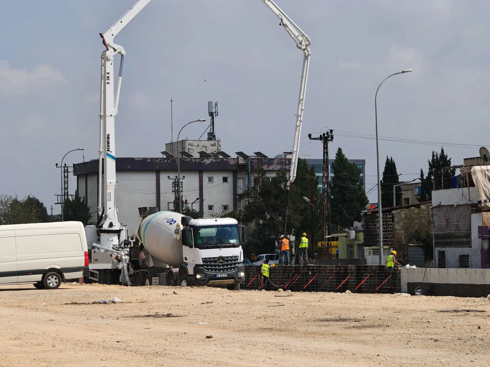 Concrete pump and ready-mix trucks working together at a commercial construction site