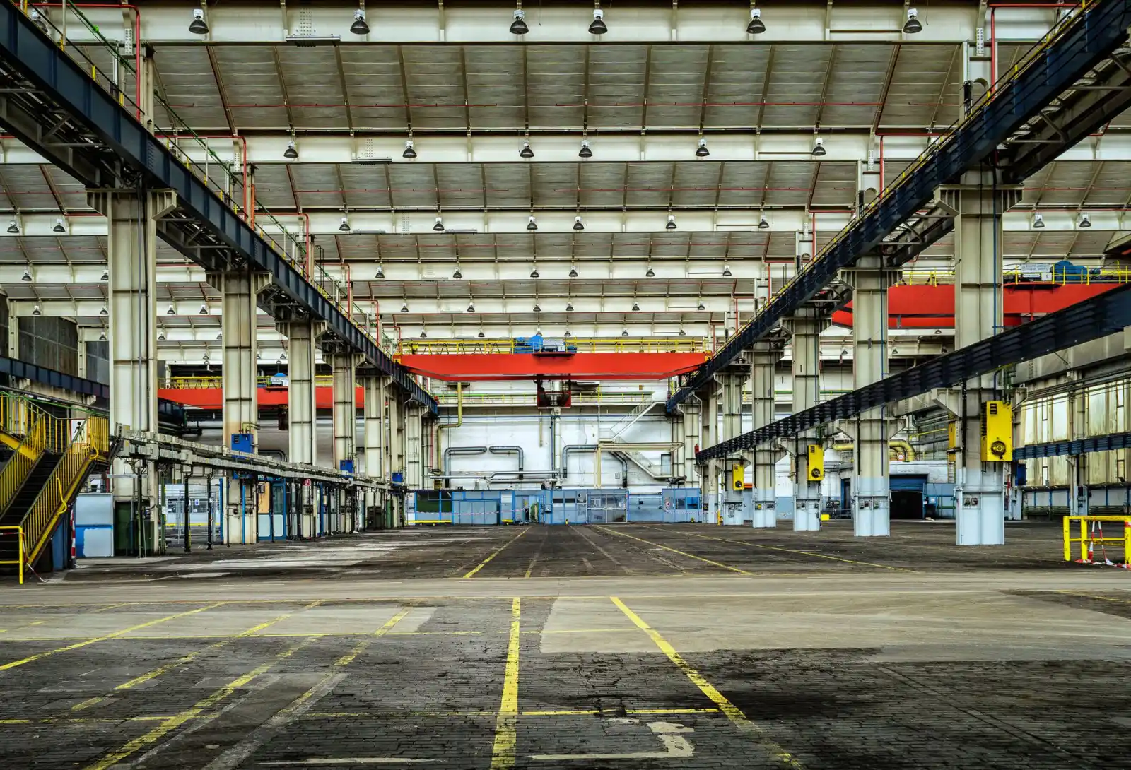 Large industrial warehouse with a concrete floor marked out with painted traffic lanes