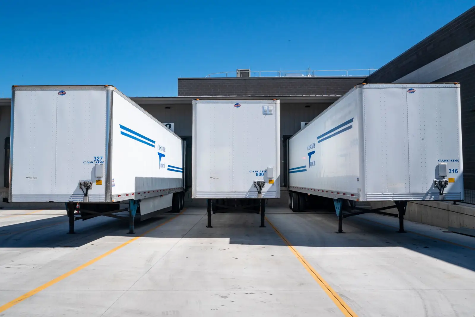 Cargo trailers parked on a concrete apron at a commercial loading dock