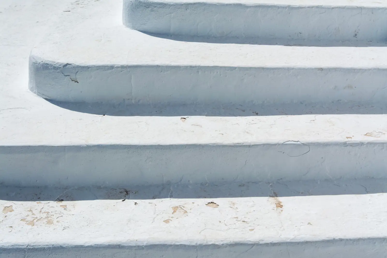 Weathered outdoor concrete steps showing surface wear along the tread edges